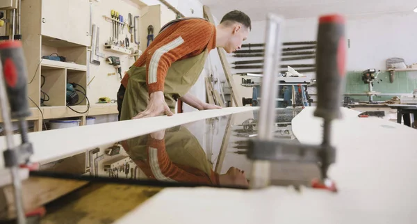 The master works on a surface grinding machine in the carpentry workshop