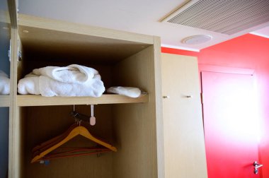 Otel odasında askıları olan açık dolap