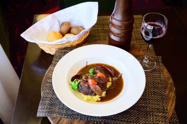 Fried meat with potatoes in a soy sauce with vegetables