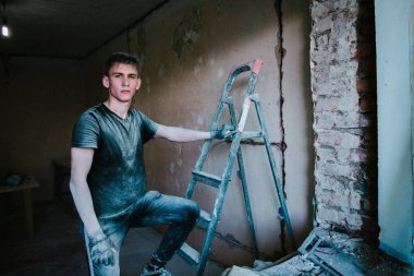 Tamir ettikten sonra kirli kıyafetlere sahip bir adam