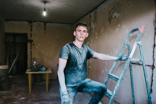Ein Mann in schmutziger Kleidung nach der Reparatur — Stockfoto