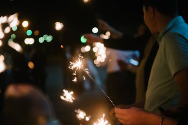 Bengal ışıkları karanlıkta bir adamın elinde yandı