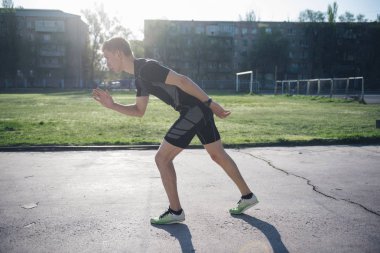 Stadyumda Atlet koşu için başlangıç pistinde duruyor