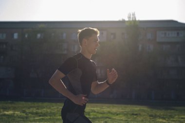 Atlet çim üzerinde kulaklık jogs