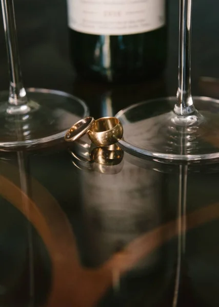 Arany jegygyűrű feküdjön egy üveg asztal közeli — Stock Fotó