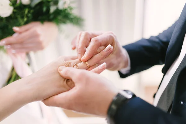 El novio le pone el anillo de bodas a la novia de cerca. La novia pone al novio en el anillo de bodas . — Foto de Stock