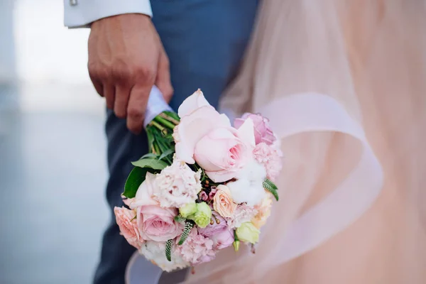 Egy férfi a ruha tart egy esküvői csokor virágok közelről. — Stock Fotó