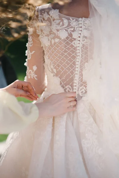 Νύφη λευκή δαντέλα νυφικό. Η νύφη βοηθάει να βάλεις το νυφικό. — Φωτογραφία Αρχείου