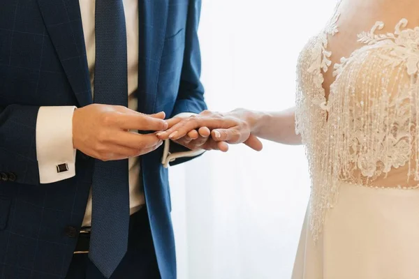 Lo sposo mette la fede nuziale sulla sposa da vicino. La sposa mette lo sposo sulla fede nuziale . — Foto Stock