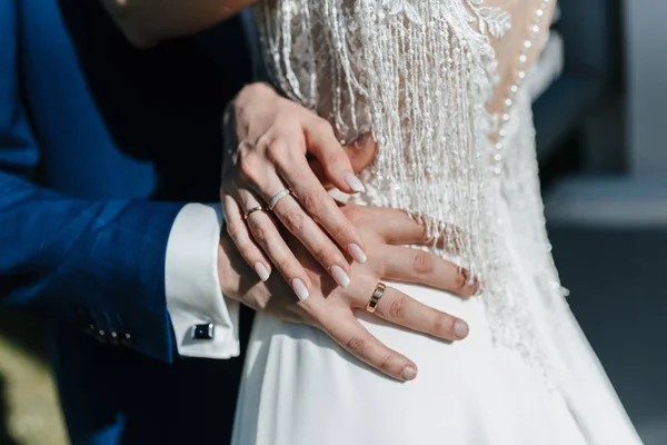 De bruidegom in een pak omhelst de bruid in een trouwjurk — Stockfoto
