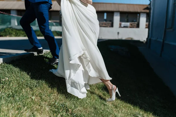 A lábak a menyasszony egy esküvői ruha cipő — Stock Fotó