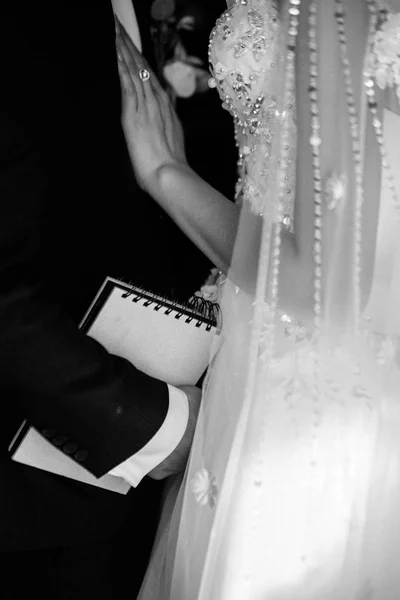 El novio en un traje abraza a la novia en un vestido de novia — Foto de Stock