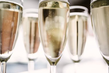 Adam bir şişeden bardağa şampanya döküyor.