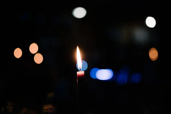 Burning wax candle in the dark in church — Stock Photo, Image