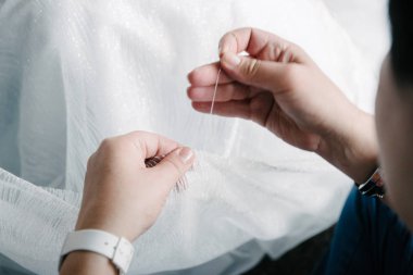 İğnesi ve ipliği olan adam yakın çekim dikiyor.