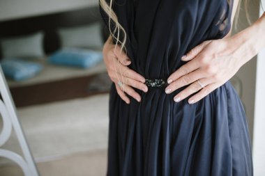 Siyah bir gece elbisesi giymiş genç bir kadın.