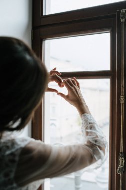 Kadın kalp şeklinde eller yapmış. Yakından.