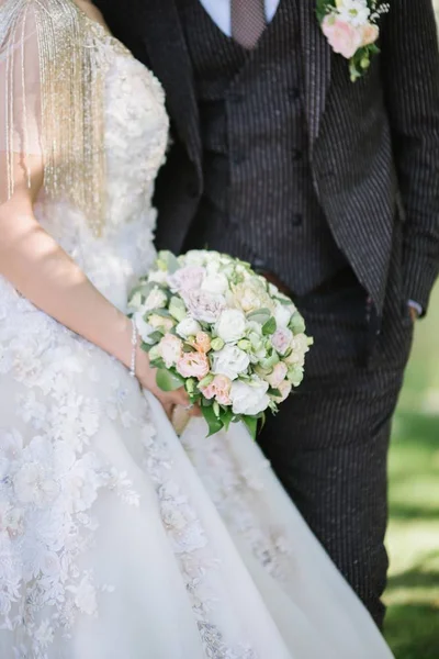 Menyasszony egy esküvői ruha tartó esküvői csokor a kezében közeli — Stock Fotó