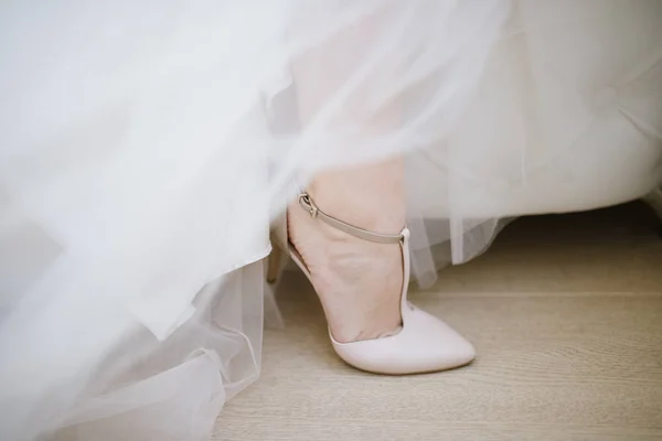 De benen van de bruid in een trouwjurk in schoenen — Stockfoto