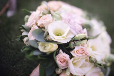 Güzel bir buket beyaz çiçek çimenlerin üzerinde yatıyor.