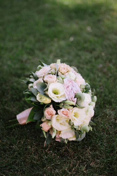 Güzel bir buket beyaz çiçek çimenlerin üzerinde yatıyor. — Stok fotoğraf