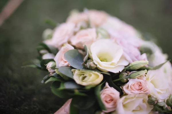 Krásná svatební kytice bílých květin leží na trávě — Stock fotografie