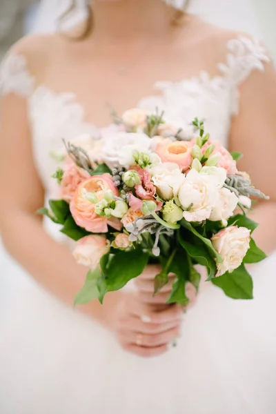 Невеста в свадебном платье с свадебным букетом в руках крупным планом — стоковое фото