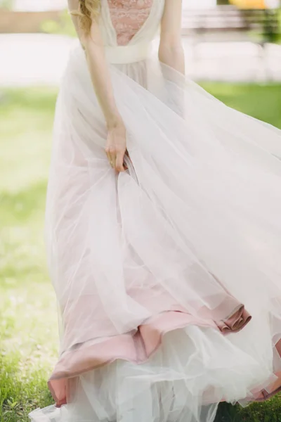 Nohy nevěsty ve svatebních šatech v botách — Stock fotografie