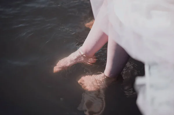 Hombre y mujer de pie con los pies en el agua en el río — Foto de Stock