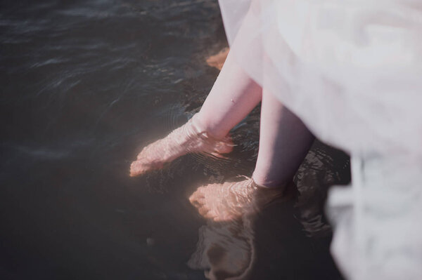 Man and woman stand with their feet in the water in the river close-up
