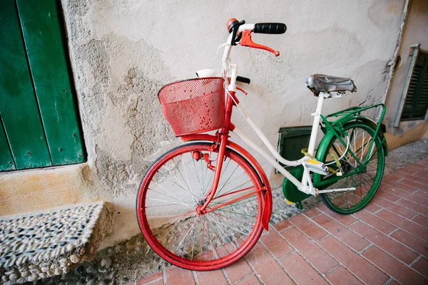 Wielokolorowy rower starego modelu stoi przy ścianie — Zdjęcie stockowe