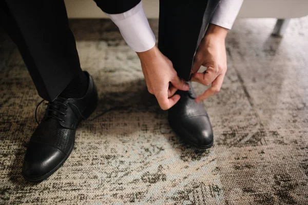 Un hombre de traje se pone zapatos en los pies. . — Foto de Stock