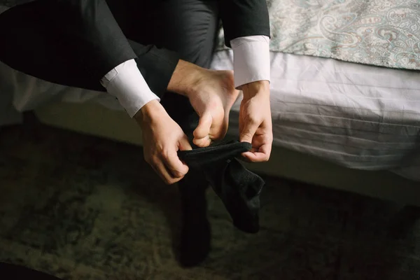 Hombre poniendo calcetines en sus pies de cerca en el dormitorio — Foto de Stock