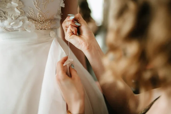 新娘白色花边婚纱。新娘帮你穿婚纱 — 图库照片