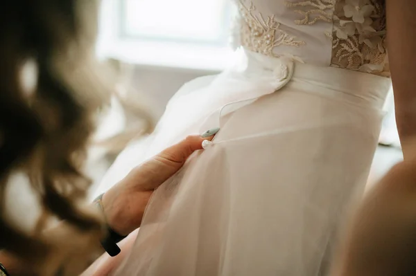 Menyasszonyi fehér csipke esküvői ruha. Menyasszony segít felvenni a menyasszonyi ruhát — Stock Fotó
