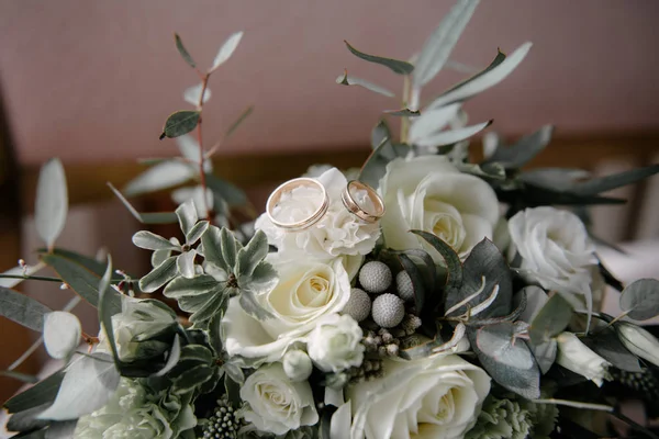 Svatební kruhy leží na květině zblízka — Stock fotografie