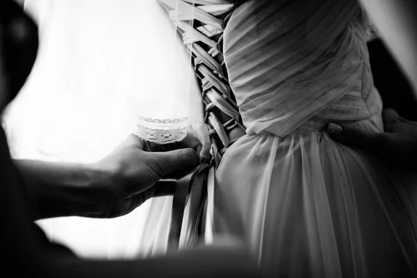 Nevěsta bílé krajkové svatební šaty. Nevěsta pomoc dát na svatební šaty — Stock fotografie