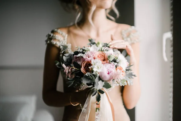 Невеста в свадебном платье с свадебным букетом в руках крупным планом — стоковое фото