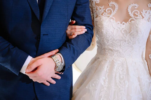 Le marié en costume étreint la mariée dans une robe de mariée — Photo