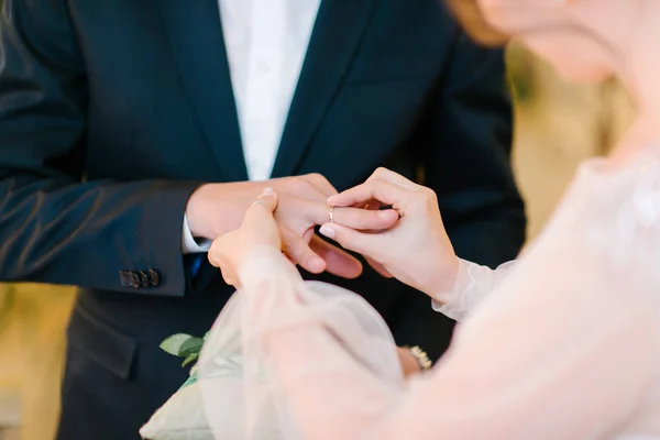 Brudgummen sätter vigselringen på bruden närbild. Bruden sätter brudgummen på vigselringen. — Stockfoto