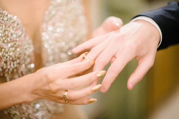 El novio le pone el anillo de bodas a la novia de cerca. La novia pone al novio en el anillo de bodas . — Foto de Stock