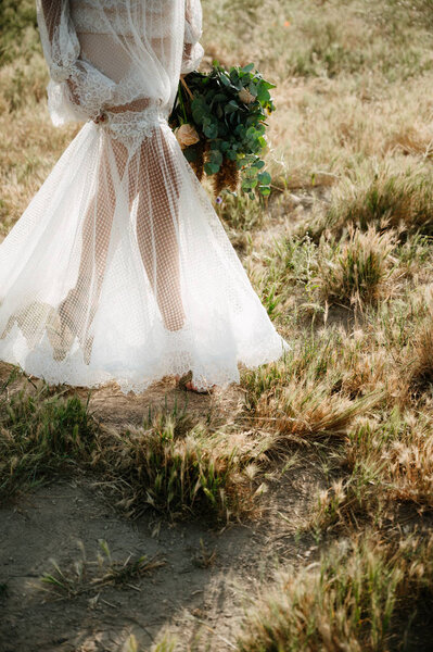 Bride in a wedding dress holding a wedding bouquet in her hands