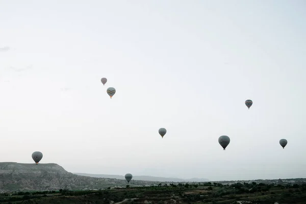 Globos de aire caliente aterrizando en una montaña Parque Nacional Capadocia Goreme Turquía . — Foto de Stock