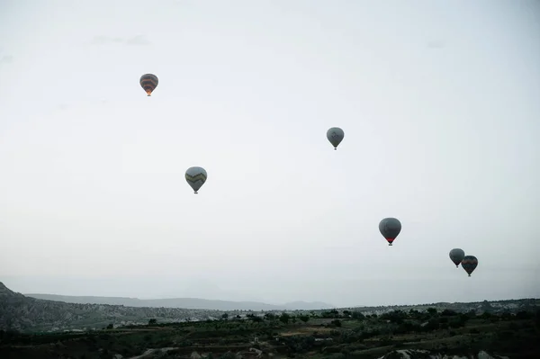 Globos de aire caliente aterrizando en una montaña Parque Nacional Capadocia Goreme Turquía . — Foto de Stock