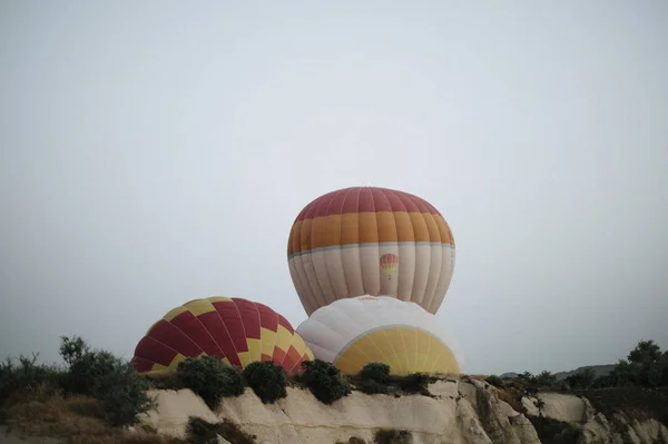 Hot air balloons landing in a mountain Cappadocia Goreme National Park Turkey. — Stock Photo, Image