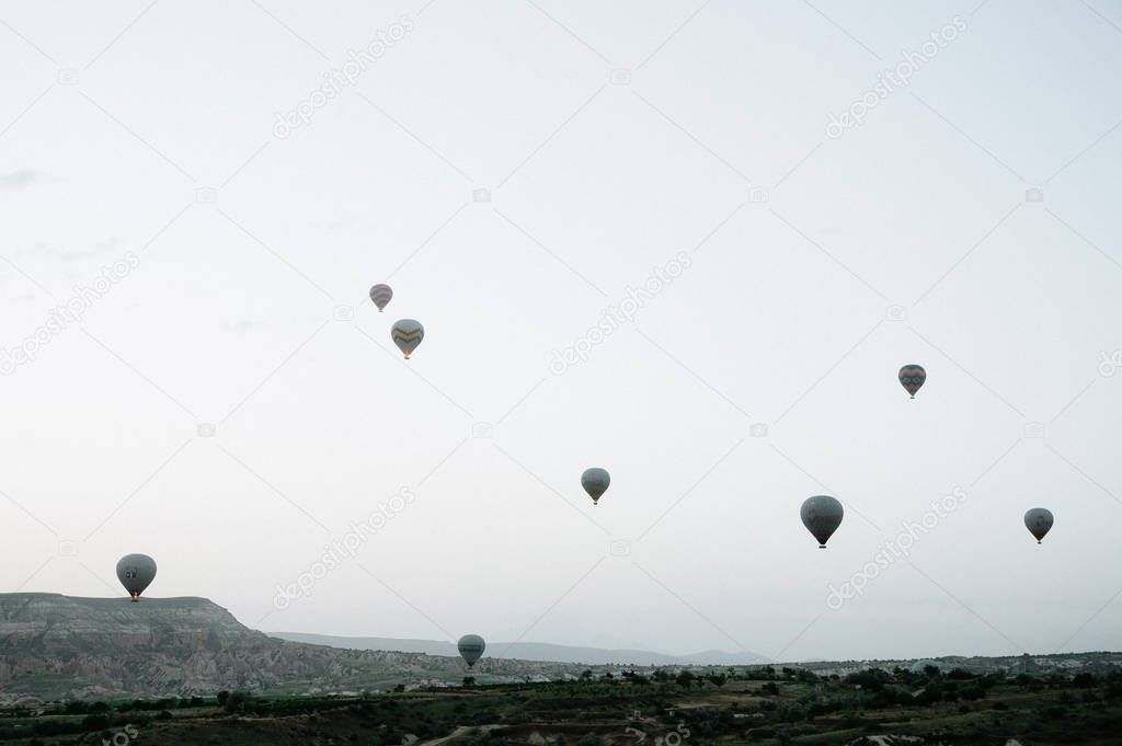 Hot air balloons landing in a mountain Cappadocia Goreme National Park Turkey.