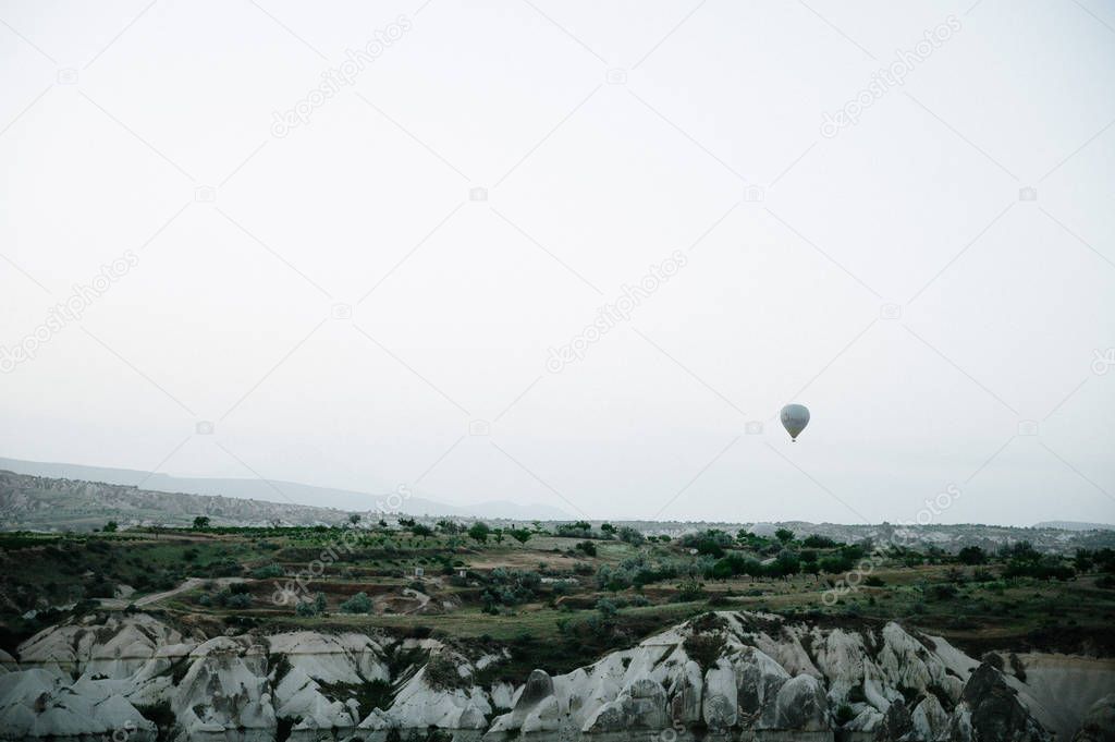 Hot air balloons landing in a mountain Cappadocia Goreme National Park Turkey.