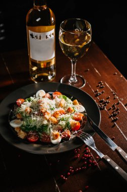 Siyah ahşap masada beyaz tabakta taze sezar salatası. Üst görünüm kopyalama alanı.