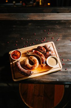 Oktoberfest yemekleri, iştah açıcı et sosisleri. Ahşap tepside geniş bir çeşit.