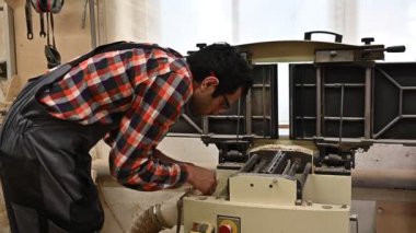 Marangozluk atölyesinde çalışma süreci. İş, marangozluk, marangozluk ve insan konsepti gibi marangozluk atölyelerinde işçi tayini kullanan işçi tulumu giyen bir adam.